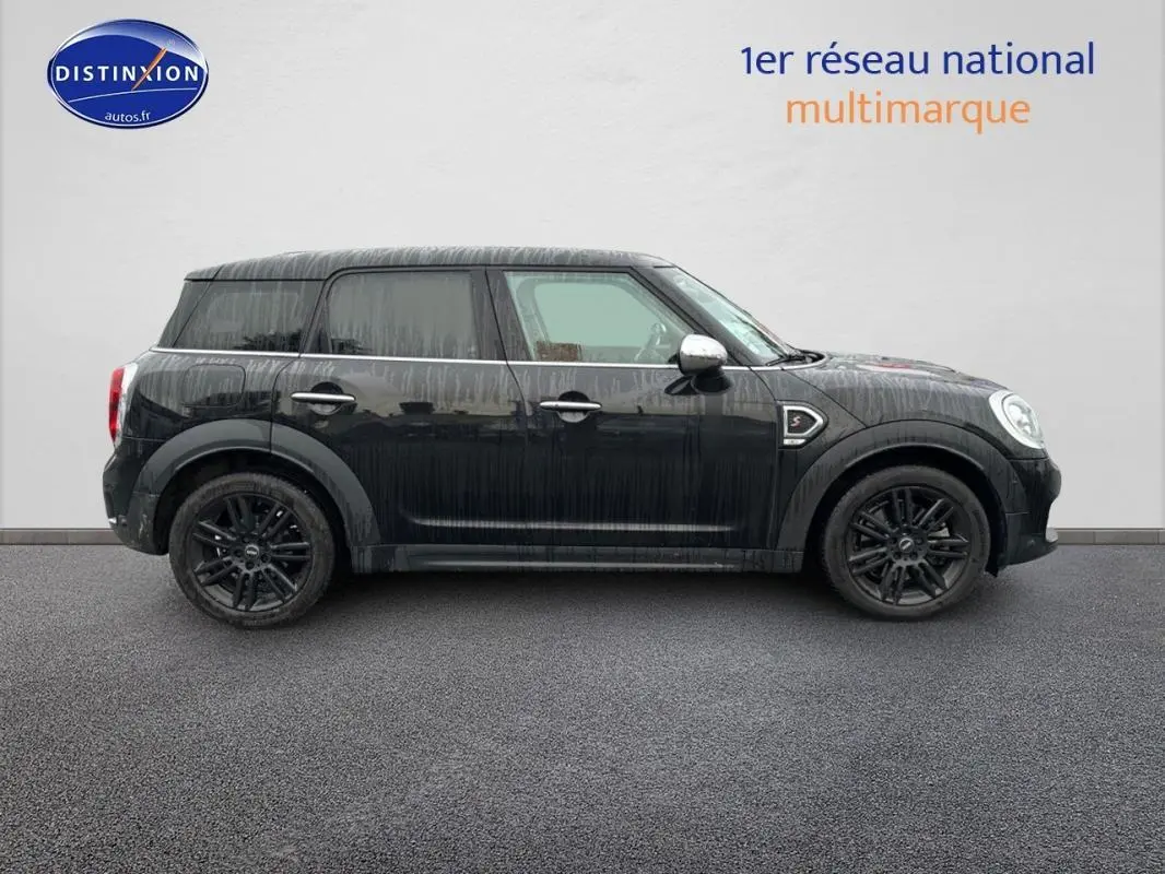 Profil côté gauche d'une MINI Countryman noire 2018 avec jantes alliage noires et rétroviseurs chromés.