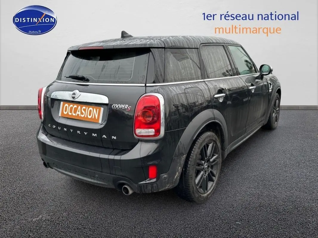 Vue 3/4 arrière droite d'une MINI Countryman noire avec jantes alliage 18 pouces et feux arrière rouges.