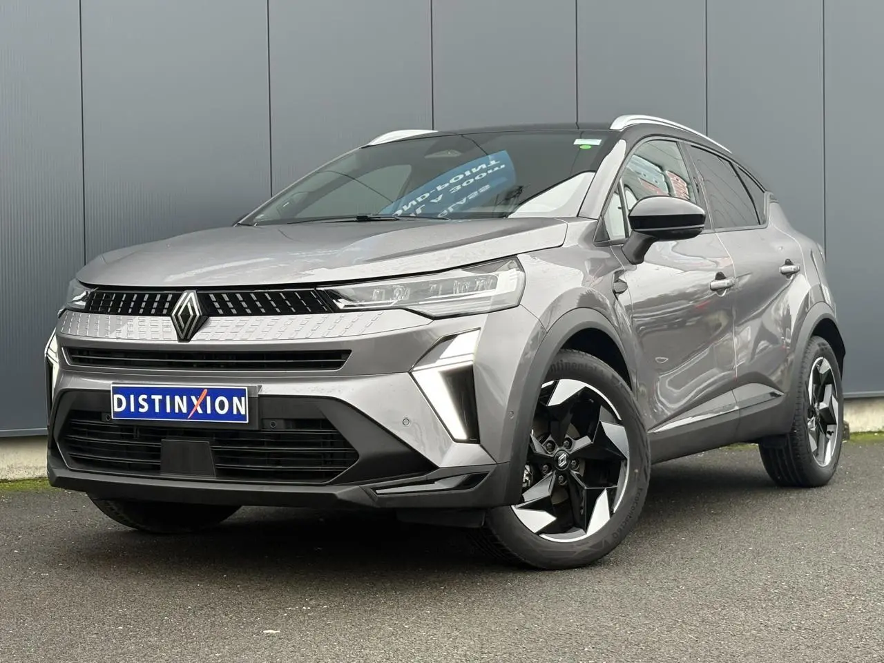 Renault Captur 2025 gris Cassiopée vue 3/4 avant droit avec jantes alu noires et toit noir métallisé.