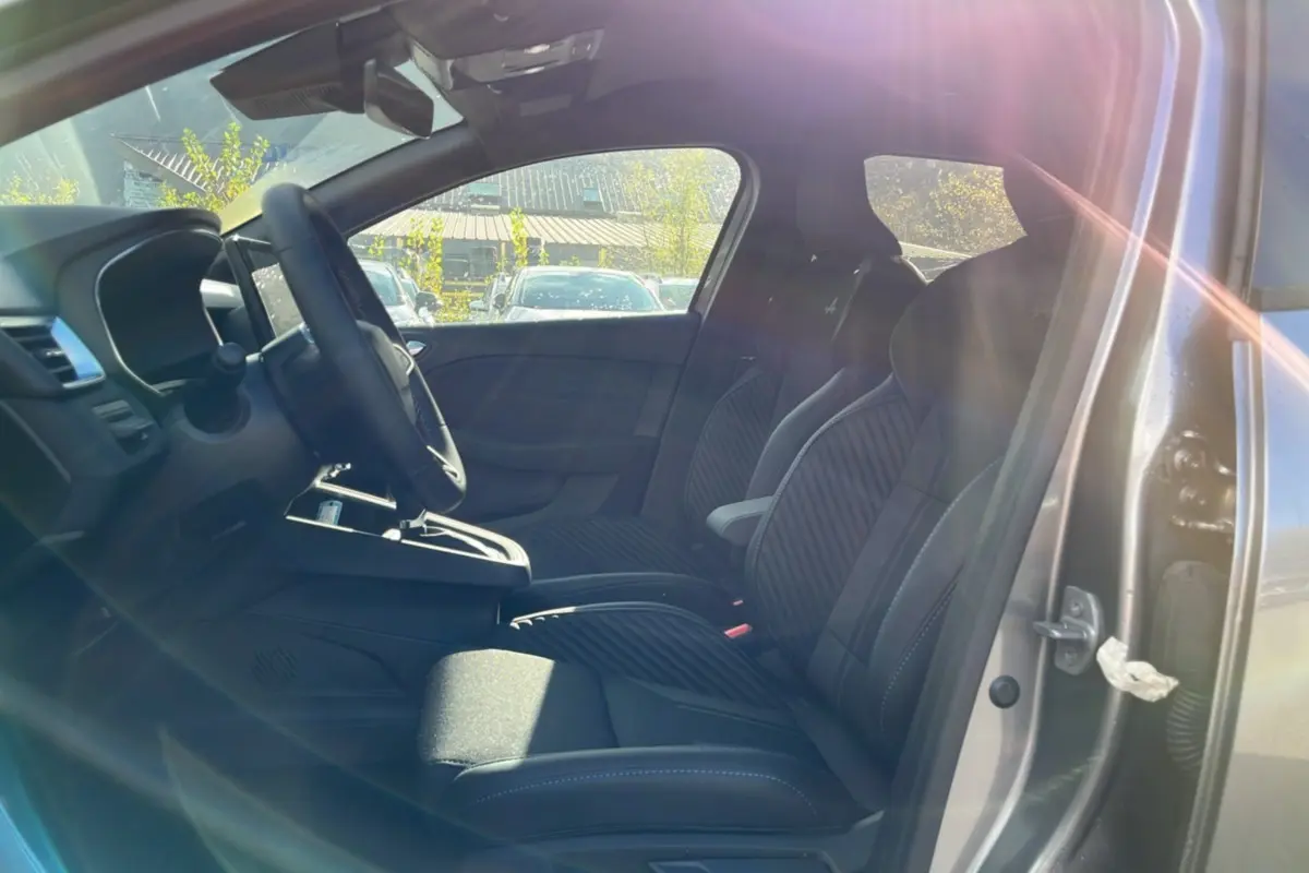 Vue intérieure côté gauche de la Renault Clio V E-Tech 145 Esprit Alpine avec sièges sport noirs et volant cuir.