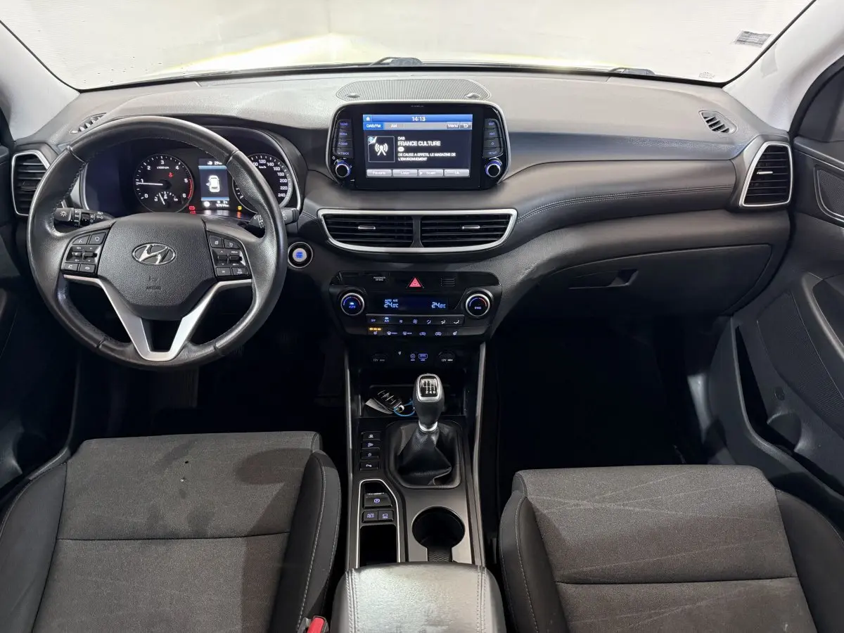 Vue intérieure frontale du tableau de bord et volant cuir noir du Hyundai Tucson 1.6 CRDI 136 Premium de 2019.