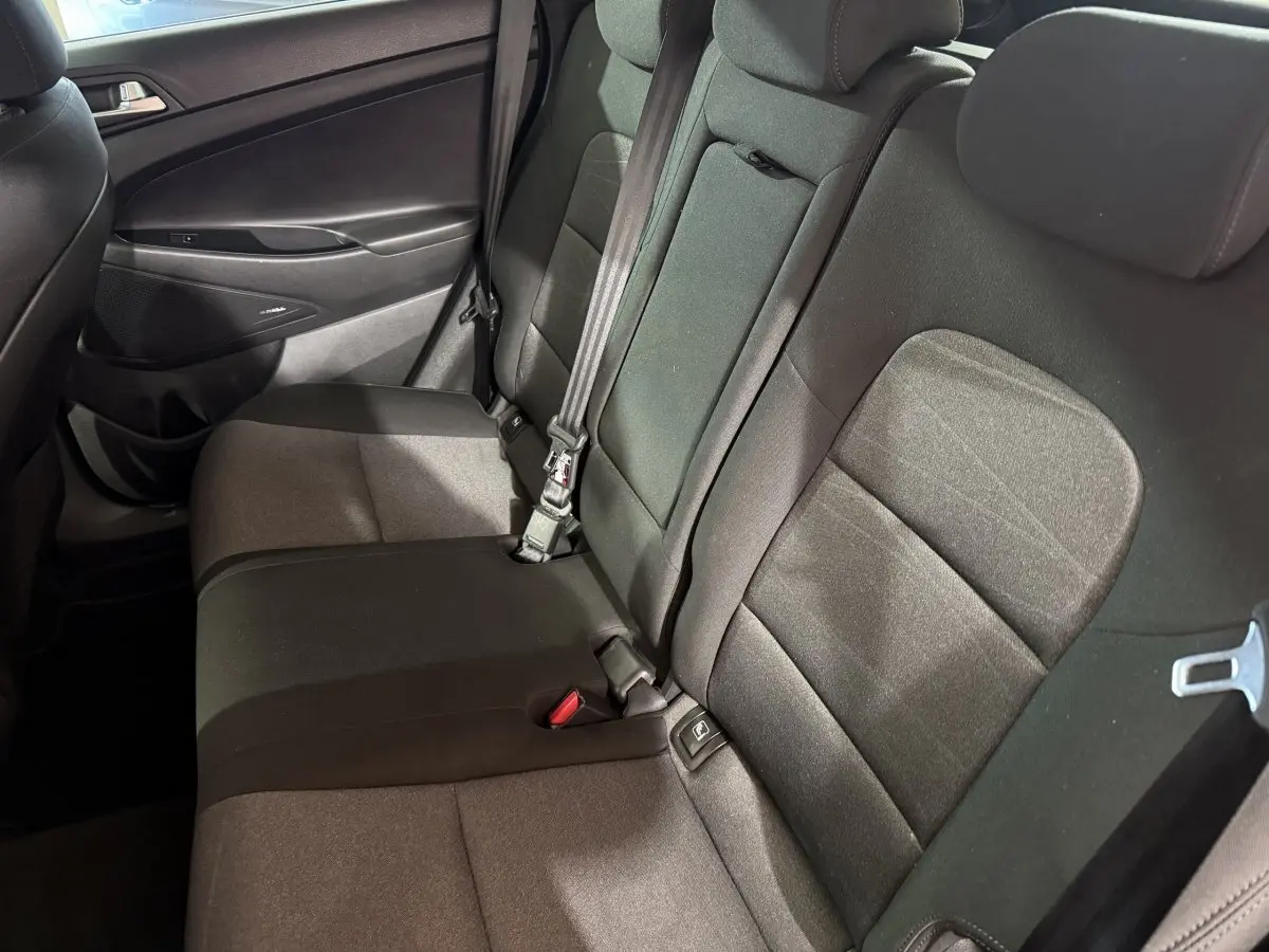 Vue intérieure côté droit sur la banquette arrière noire du Hyundai Tucson 2019, avec ceinture de sécurité visible.