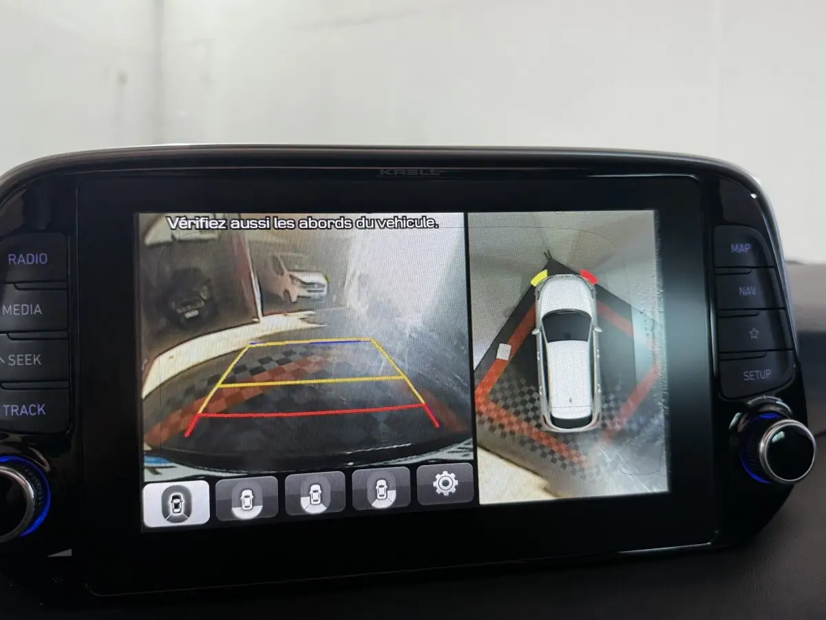 Écran tactile intérieur montrant la caméra de recul et vue à 360° du Hyundai Tucson noir en stationnement.