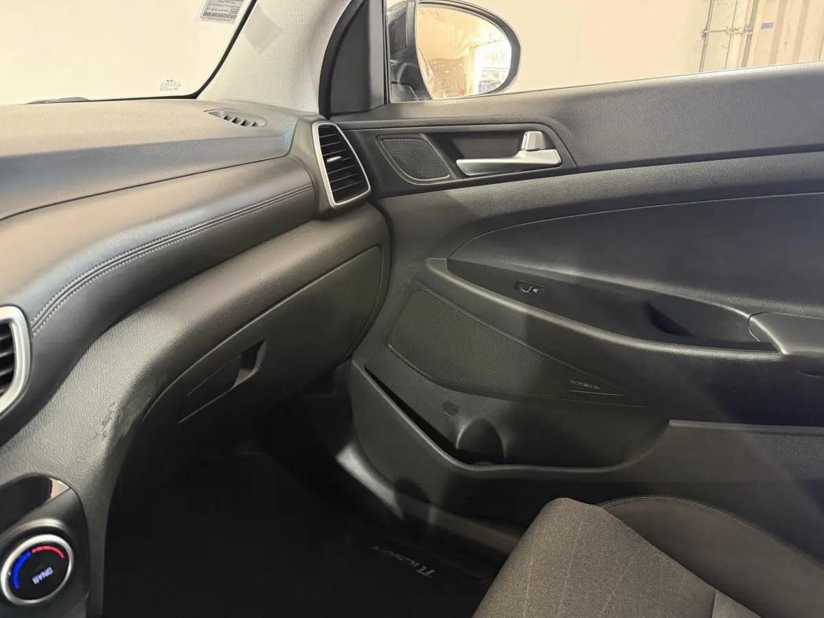 Vue intérieure côté passager du tableau de bord noir et de la porte d’une Hyundai Tucson 2019 finition Premium.