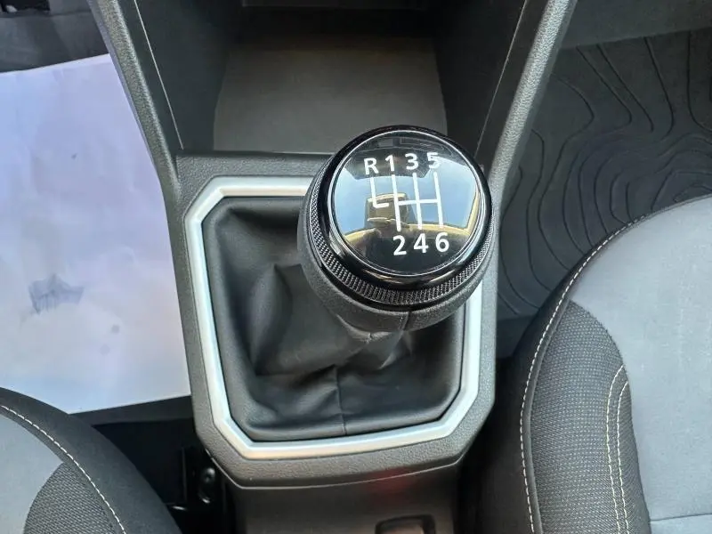 Le levier de vitesses manuel noir de la Dacia Sandero 1.0 ECO-G 100ch Stepway Extreme, vu de dessus, avec coutures grises visibles.