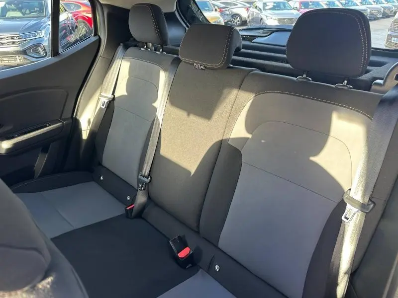 Vue intérieure de la banquette arrière bicolore grise et noire du Dacia Sandero Stepway 2025, avec ceintures de sécurité visibles.