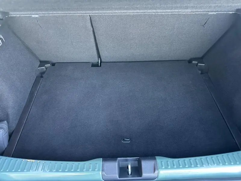 Vue intérieure du coffre spacieux et propre d'une Dacia Sandero 2025 blanc glacier, montrant le plancher et les parois rembourrées.