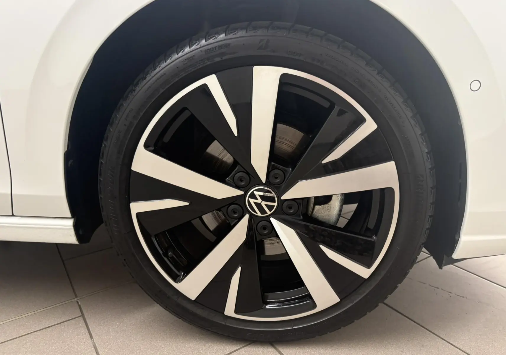 Gros plan sur la jante alliage 18'' Catania noire et argentée de la Volkswagen Golf Blanc Oryx nacré, côté gauche.