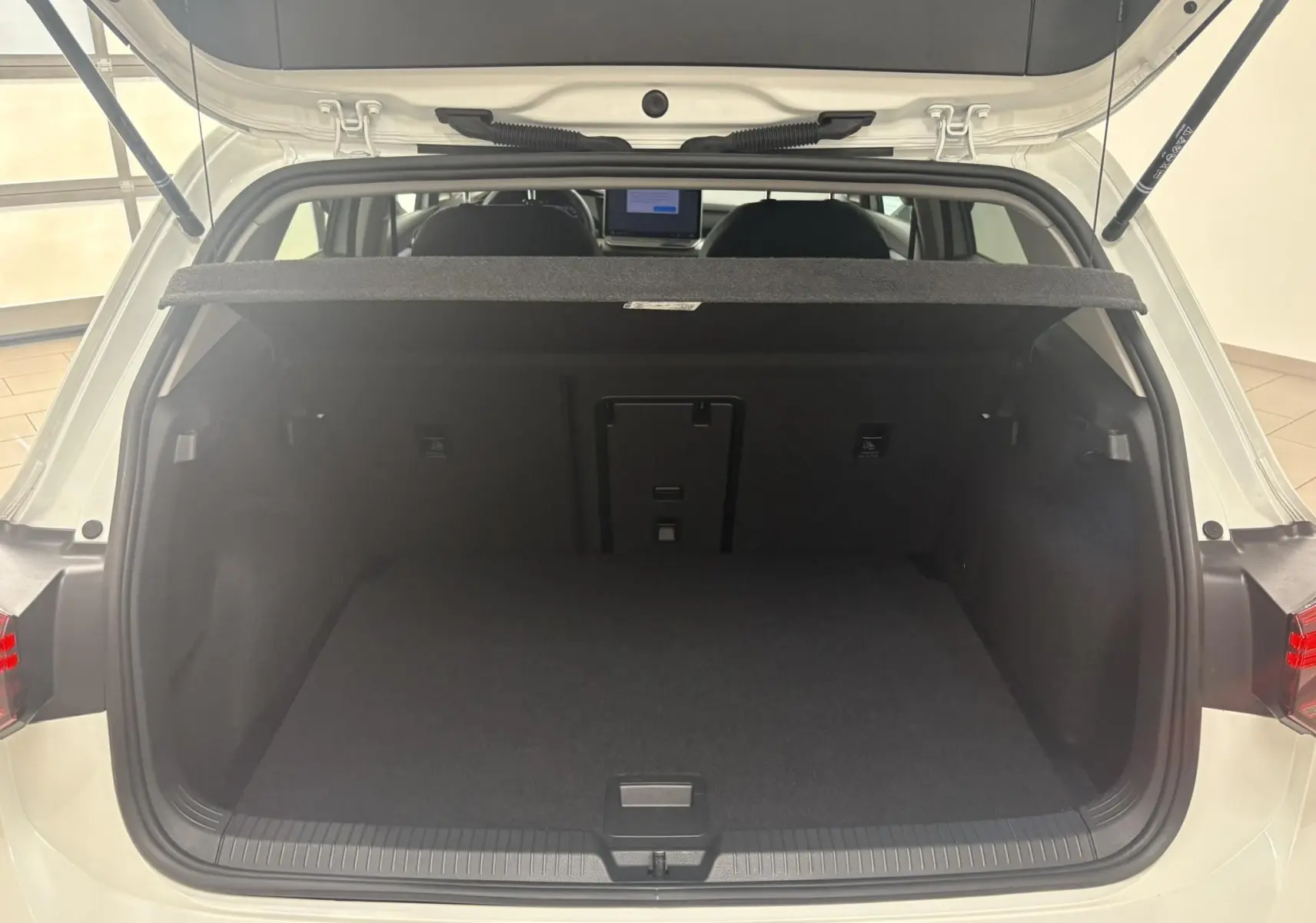 Coffre ouvert vu de l'arrière d'une Volkswagen Golf 1.5 eTSI 116 BVM6 VW Edition blanc Oryx nacré, intérieur noir.
