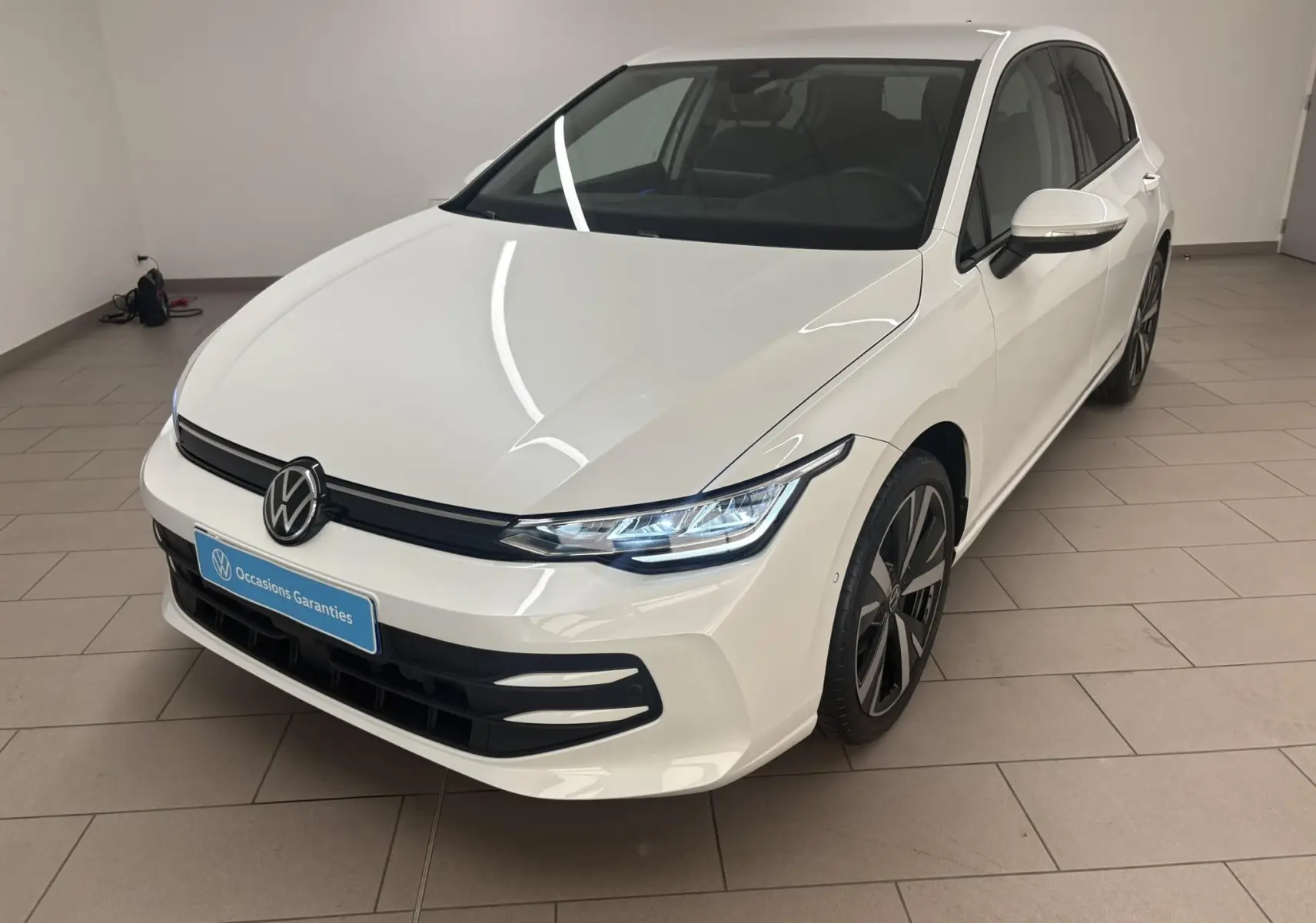 Vue 3/4 avant droite d'une Volkswagen Golf 1.5 eTSI blanche nacrée avec jantes alliage 18 pouces Catania.
