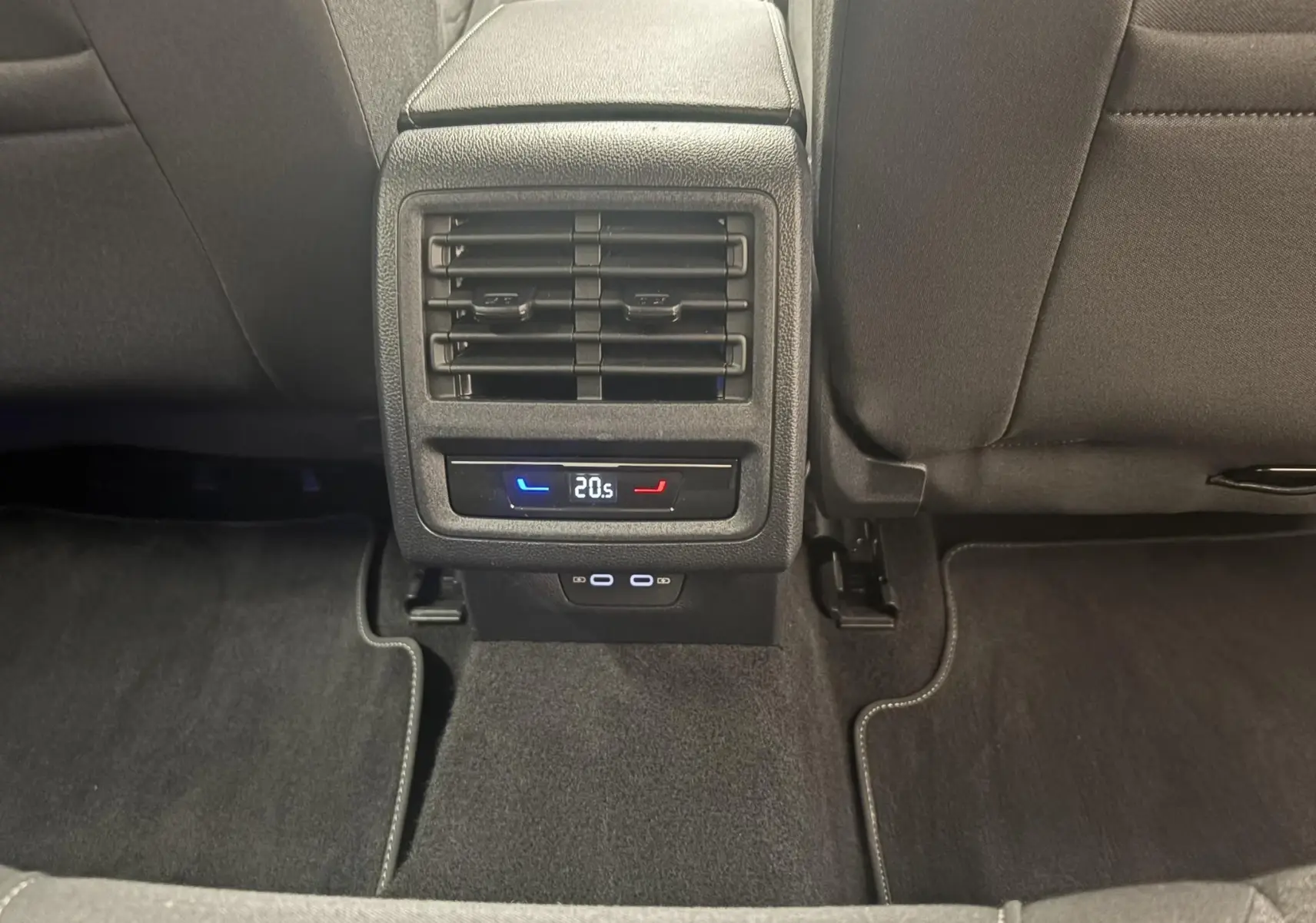 Vue rapprochée de la console arrière noire avec bouches d’aération et réglage de climatisation dans une Volkswagen Golf 2025.