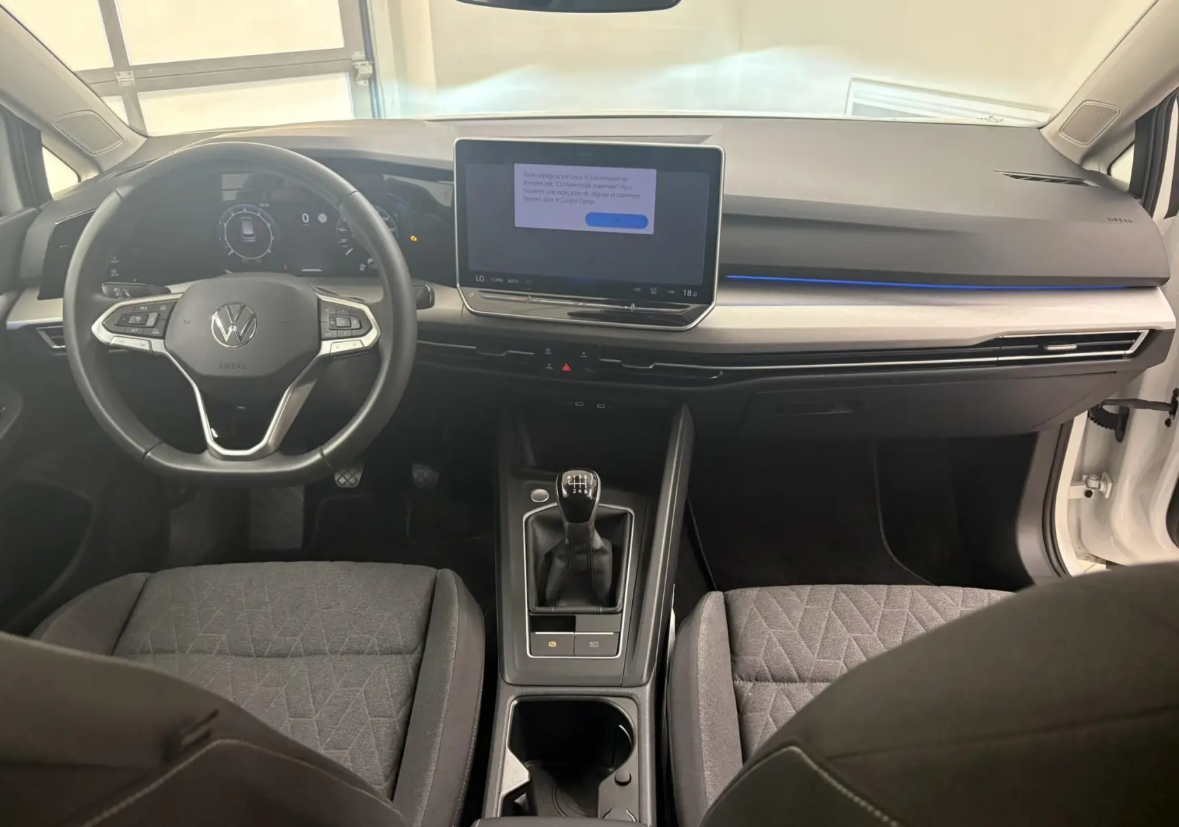 Vue intérieure avant de la Volkswagen Golf 1.5 eTSI 116 BVM6 avec tableau de bord moderne et volant multifonction.