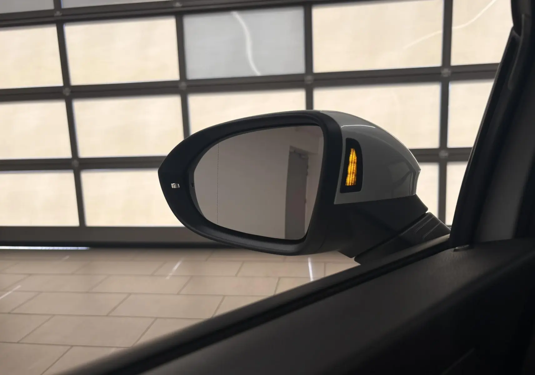 Rétroviseur extérieur droit blanc nacré de Volkswagen Golf 1.5 eTSI 2025 avec clignotant orange allumé.
