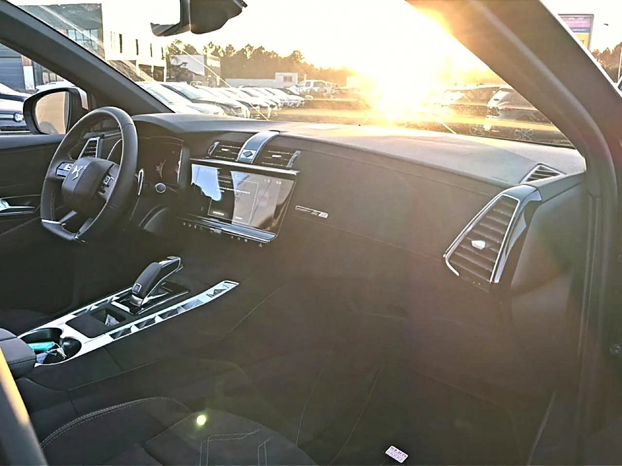 Intérieur du DS7 1.5 BlueHDi 130 noir, vue côté conducteur avec tableau de bord et écran tactile au soleil couchant.