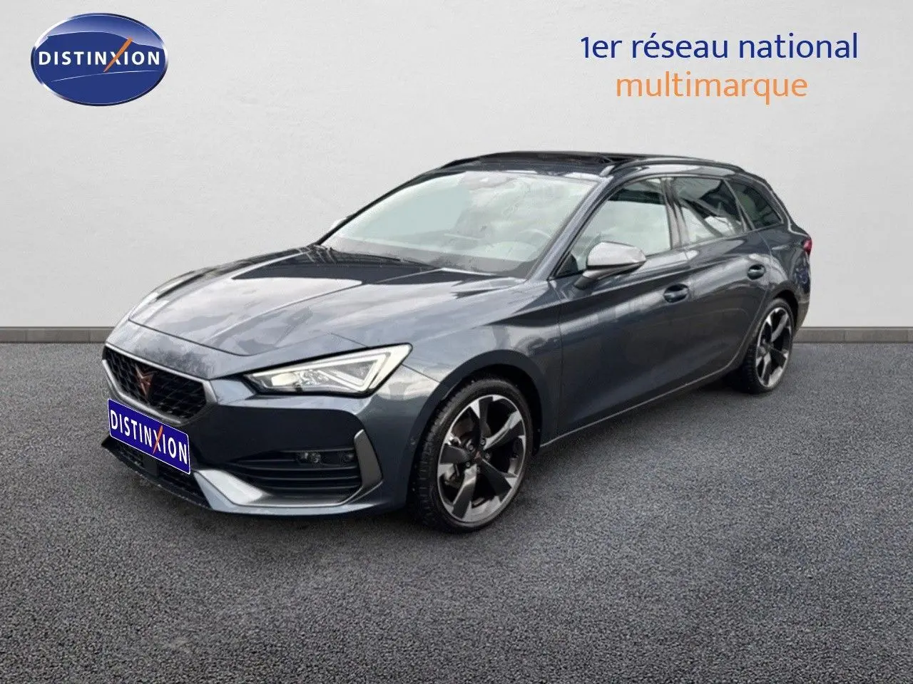Vue 3/4 avant d'une CUPRA LEON ST gris magnétique avec jantes bi-ton et calandre distinctive.
