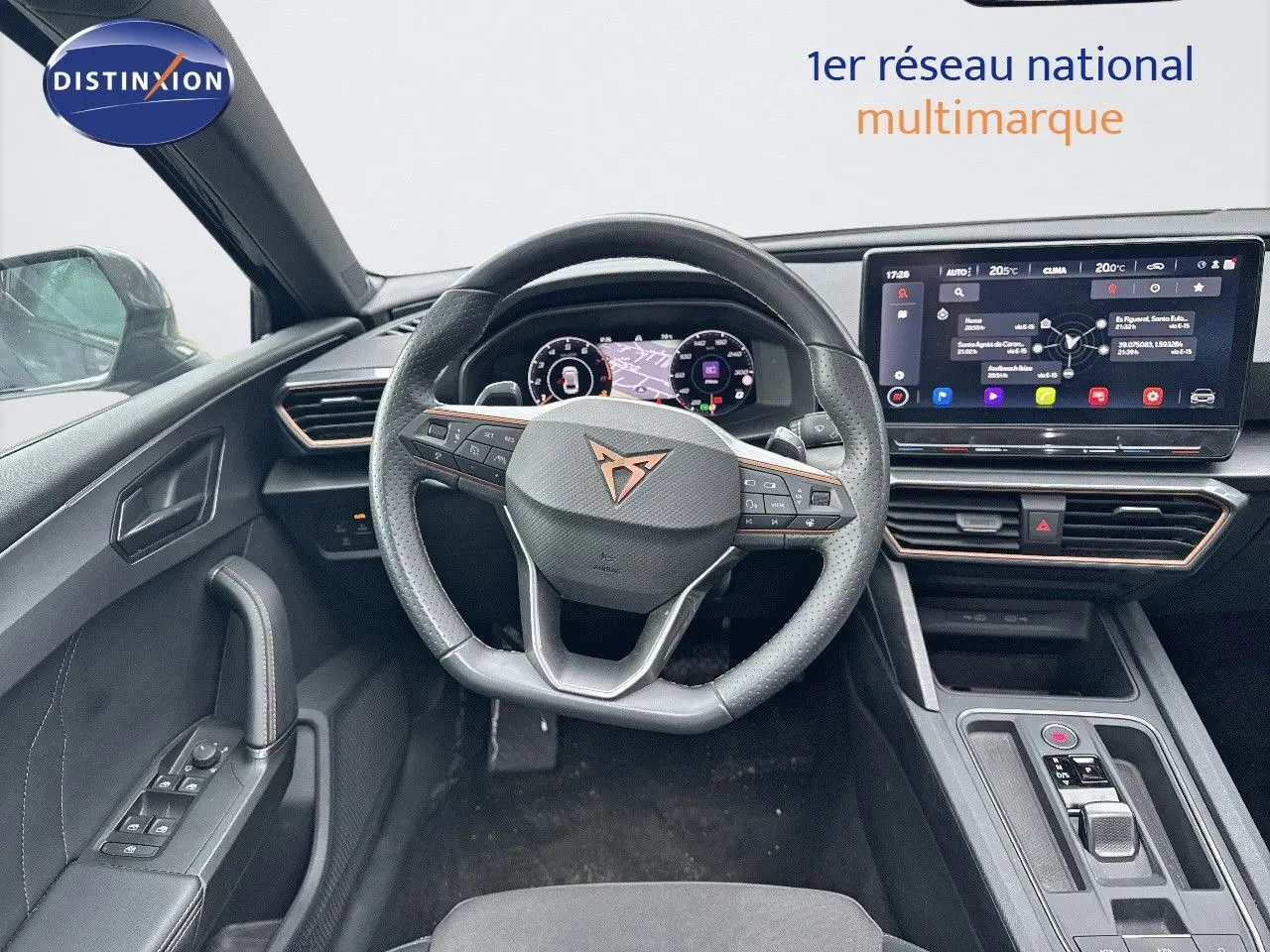 Vue intérieure centrée sur le volant CUPRA avec tableau de bord numérique et écran tactile moderne.