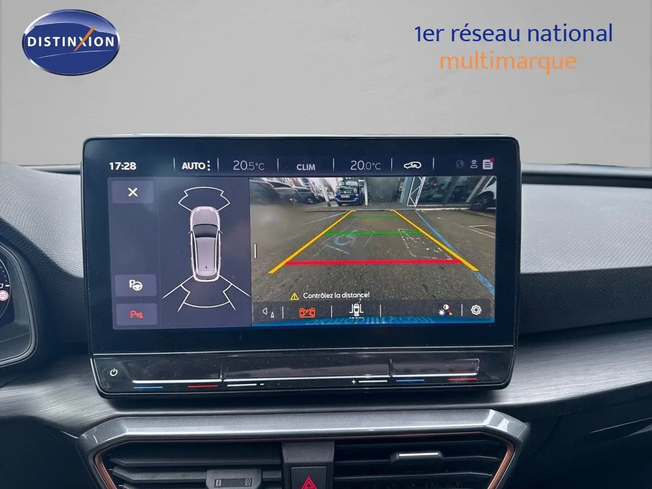 Écran central du tableau de bord de la CUPRA LEON ST gris magnétique montrant la caméra de recul et les capteurs de stationnement.
