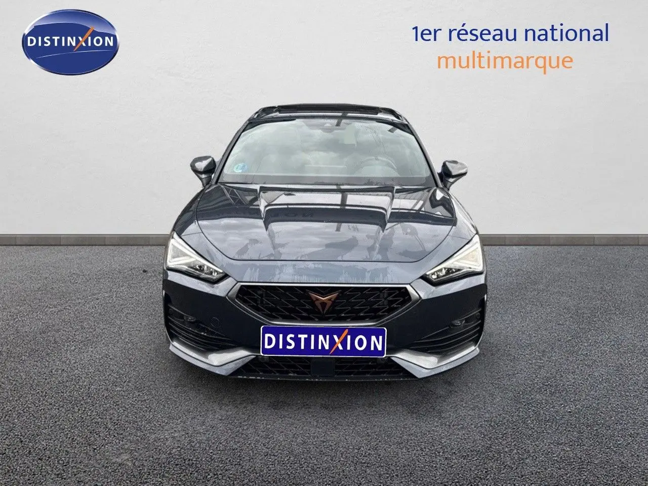 Vue frontale d'une CUPRA LEON ST 1.5 ETSI 150CH DSG gris magnétique avec calandre noire et détails argentés.