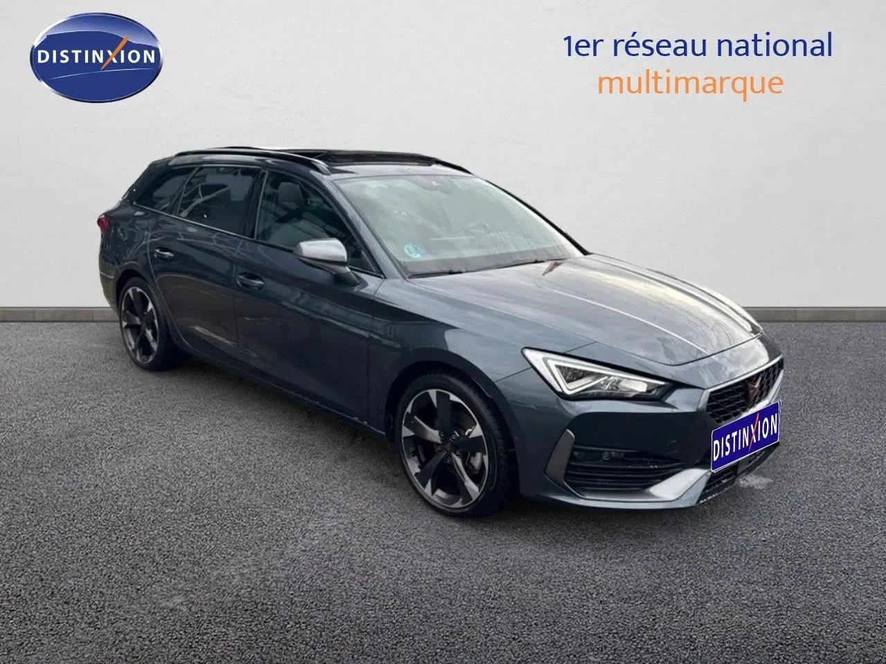 Vue 3/4 avant droite d'une CUPRA LEON ST gris magnétique avec jantes bi-ton et calandre distinctive.