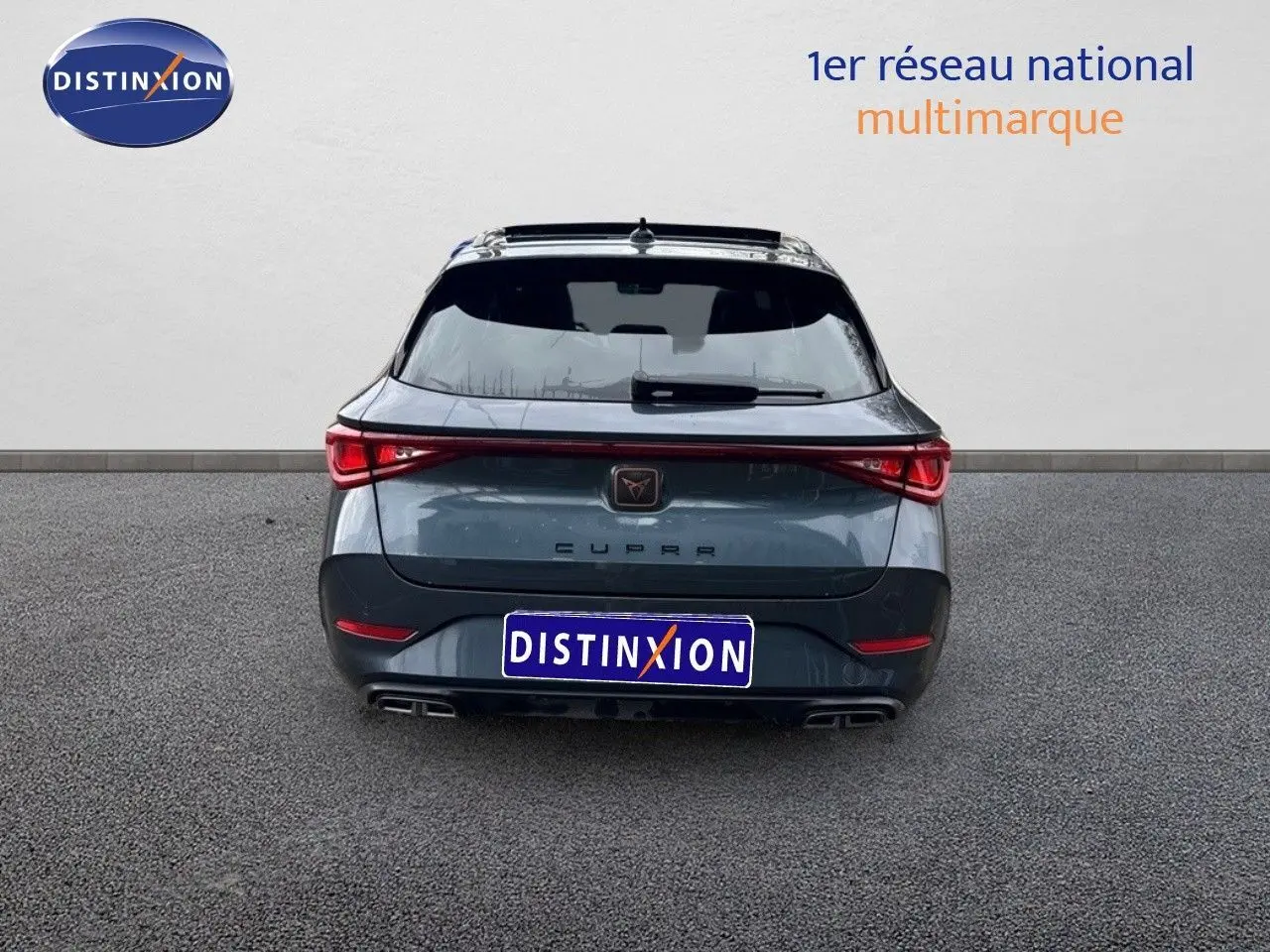 Vue arrière d'une CUPRA LEON ST gris magnétique avec feux LED reliés et double sortie d'échappement intégrée.