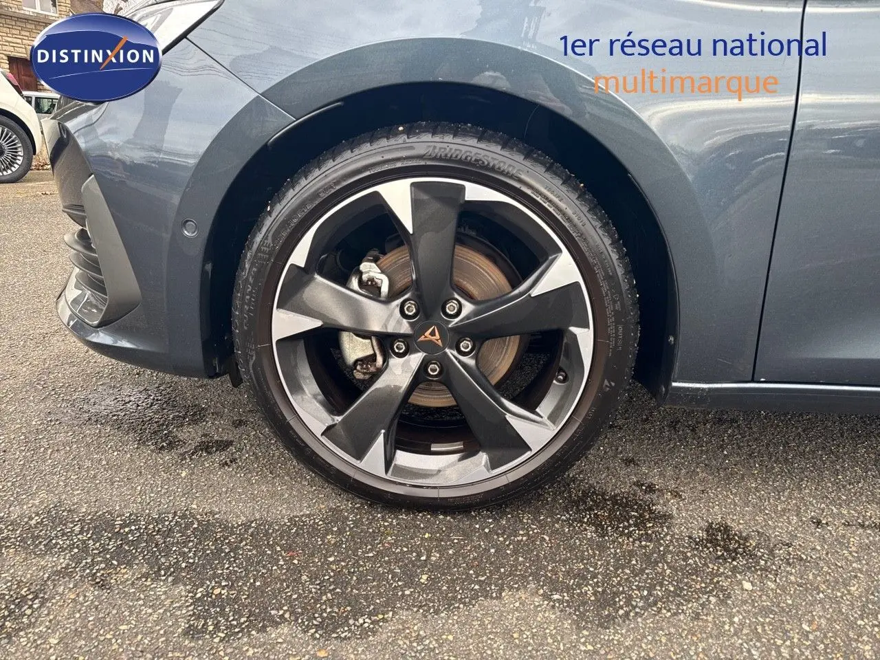 Gros plan sur la roue avant gauche d'une CUPRA LEON ST gris magnétique avec jante bi-ton distinctive.