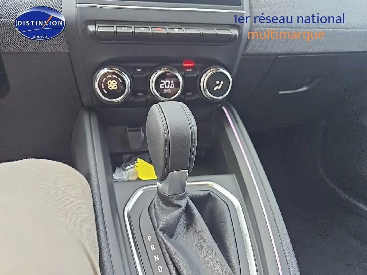 Le levier de boîte automatique de la Renault Clio V gris schiste, avec commandes de climatisation et éclairage d'ambiance violet.