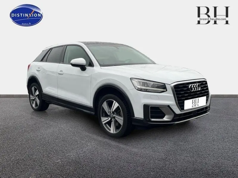 Audi Q2 blanc Ibis vue 3/4 avant droit, jantes alu 18 pouces et vitres surteintées visibles