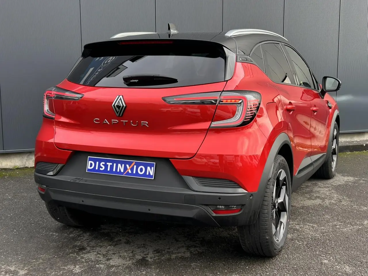 Vue 3/4 arrière droite du Renault Captur 2025 rouge Flamme avec toit noir et jantes alu noires diamantées.