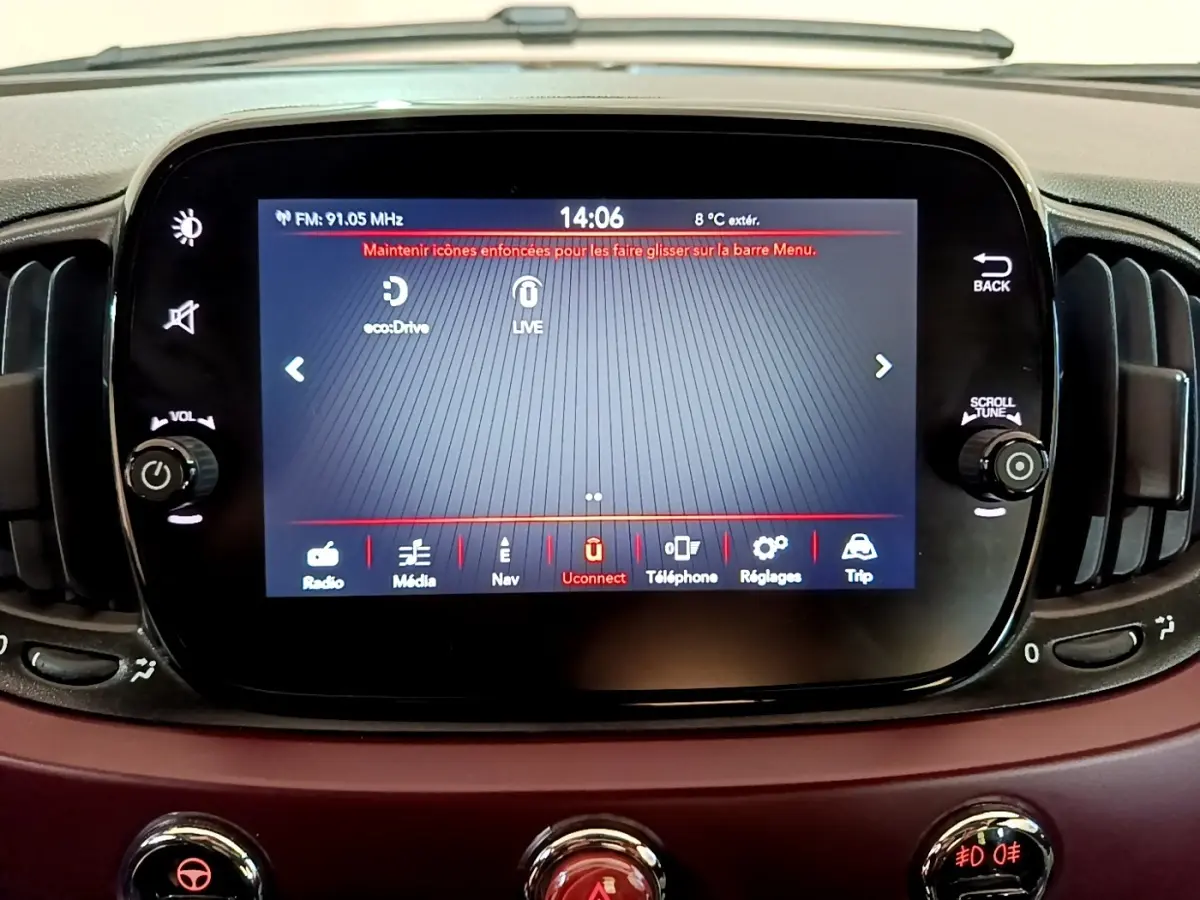 Écran tactile central du tableau de bord d’une FIAT 500 rouge, affichant le menu Uconnect et commandes autour.