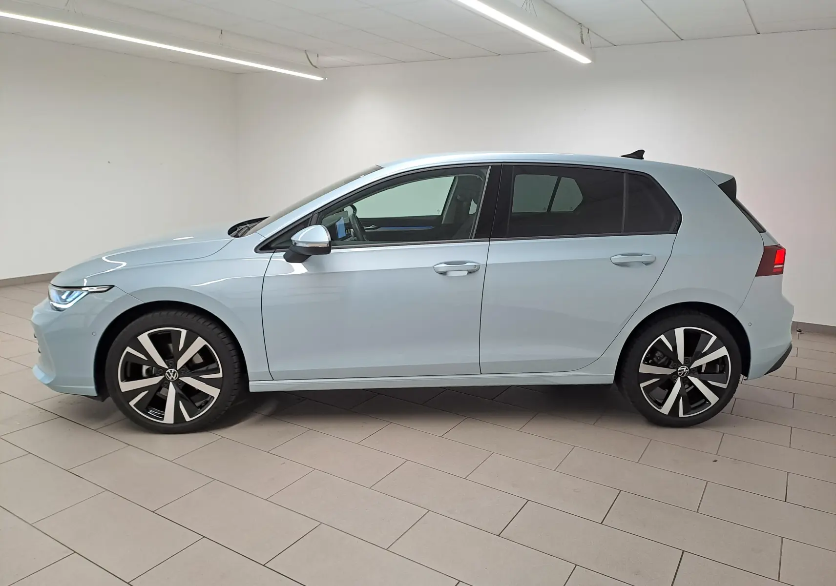 Profil droit d'une Volkswagen Golf 1.5 eTSI 116 DSG7 VW Edition bleu glacier avec jantes alliage 18 pouces Catania.