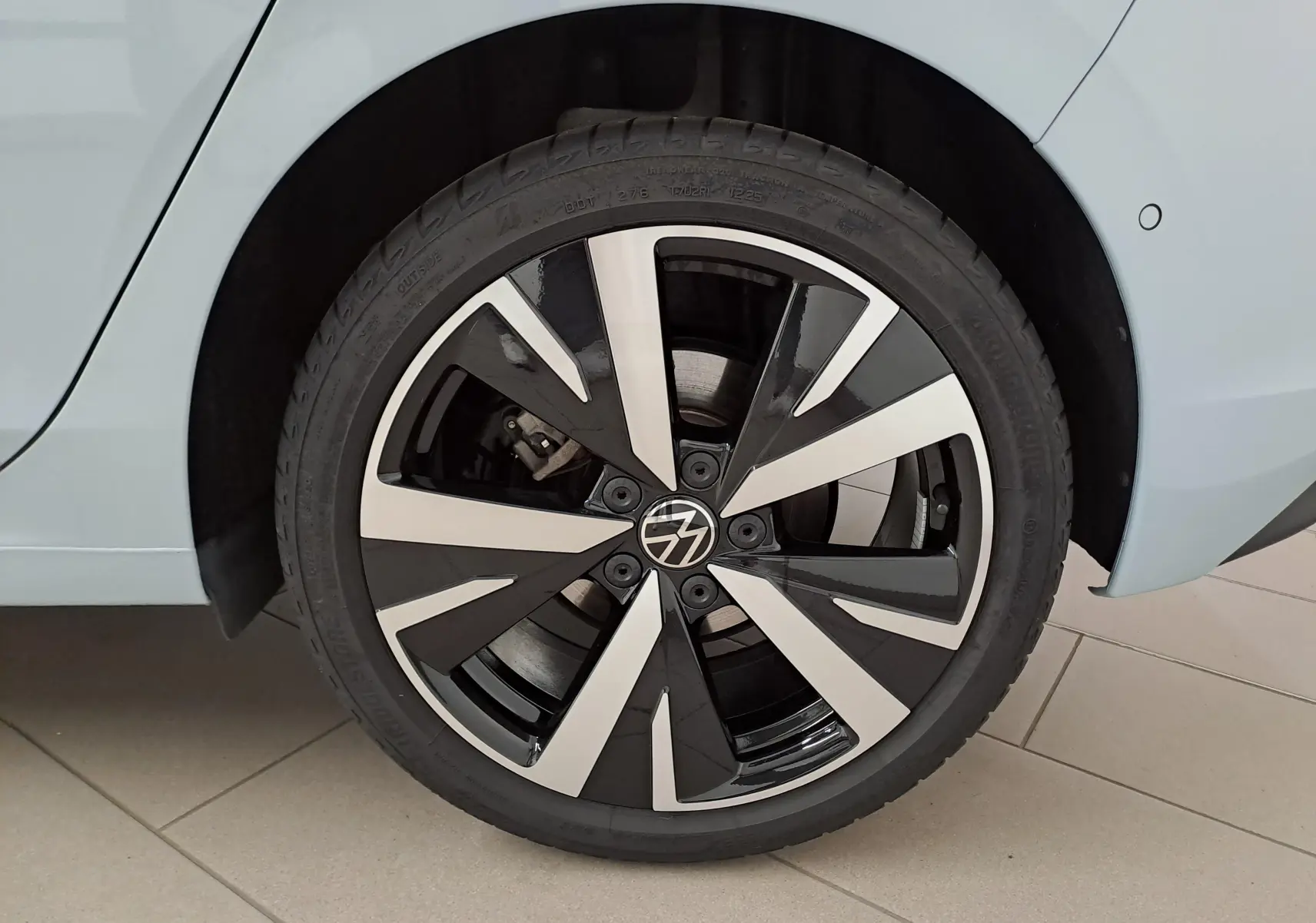 Gros plan sur la jante alliage 18'' Catania noire et argentée de la Volkswagen Golf Bleu Glacier côté arrière droit.