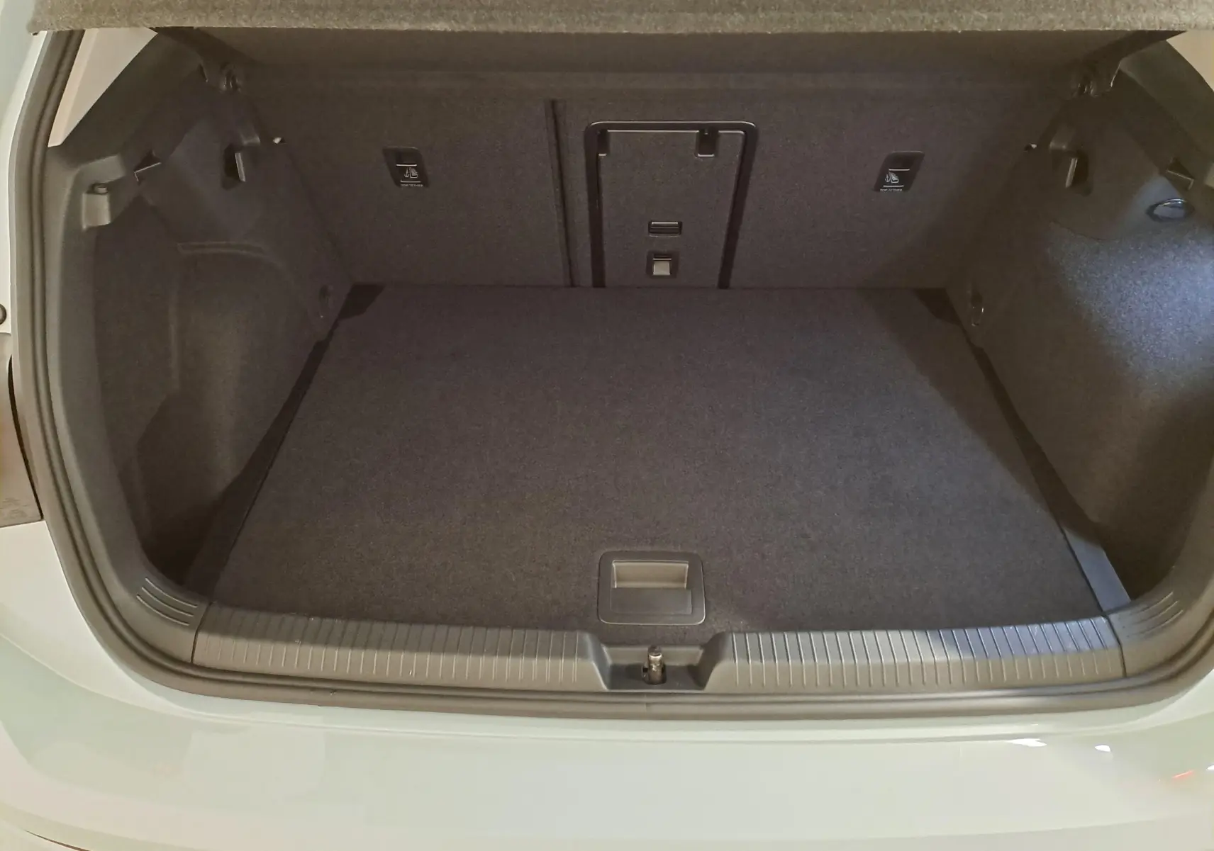 Coffre ouvert vu de l'arrière d'une Volkswagen Golf 1.5 eTSI 116 DSG7 Bleu Glacier, espace de chargement vide et propre.