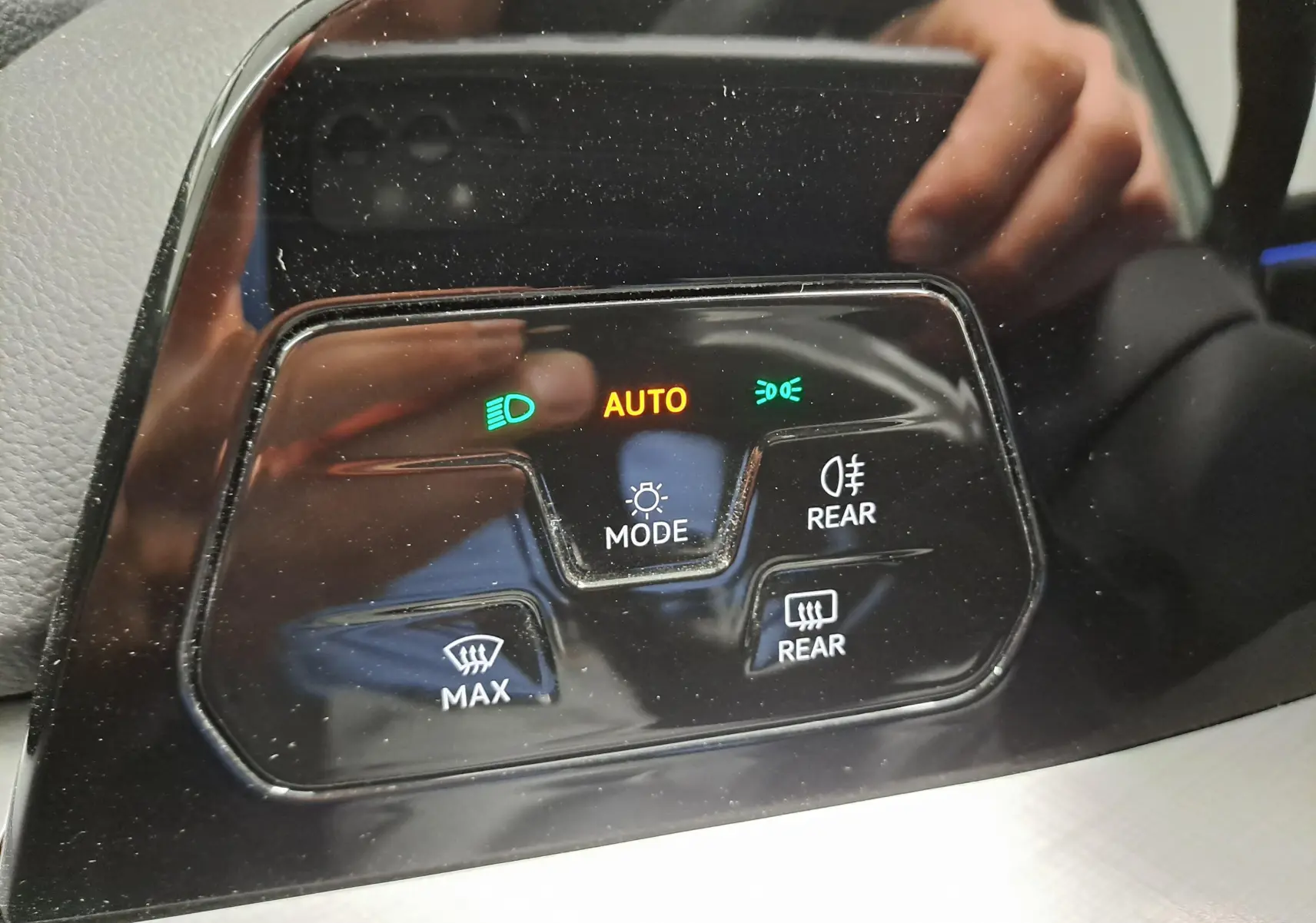 Gros plan sur les commandes d’éclairage et désembuage arrière du tableau de bord d’une Volkswagen Golf Bleu Glacier.
