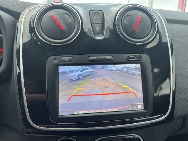Vue rapprochée de l’écran central du tableau de bord d’une Dacia Logan MCV rouge, affichant la caméra de recul.