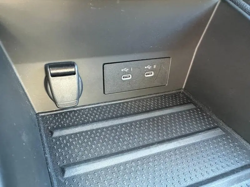Détail intérieur du coffre du Renault Symbioz rouge, montrant deux ports USB-C et une prise 12V.