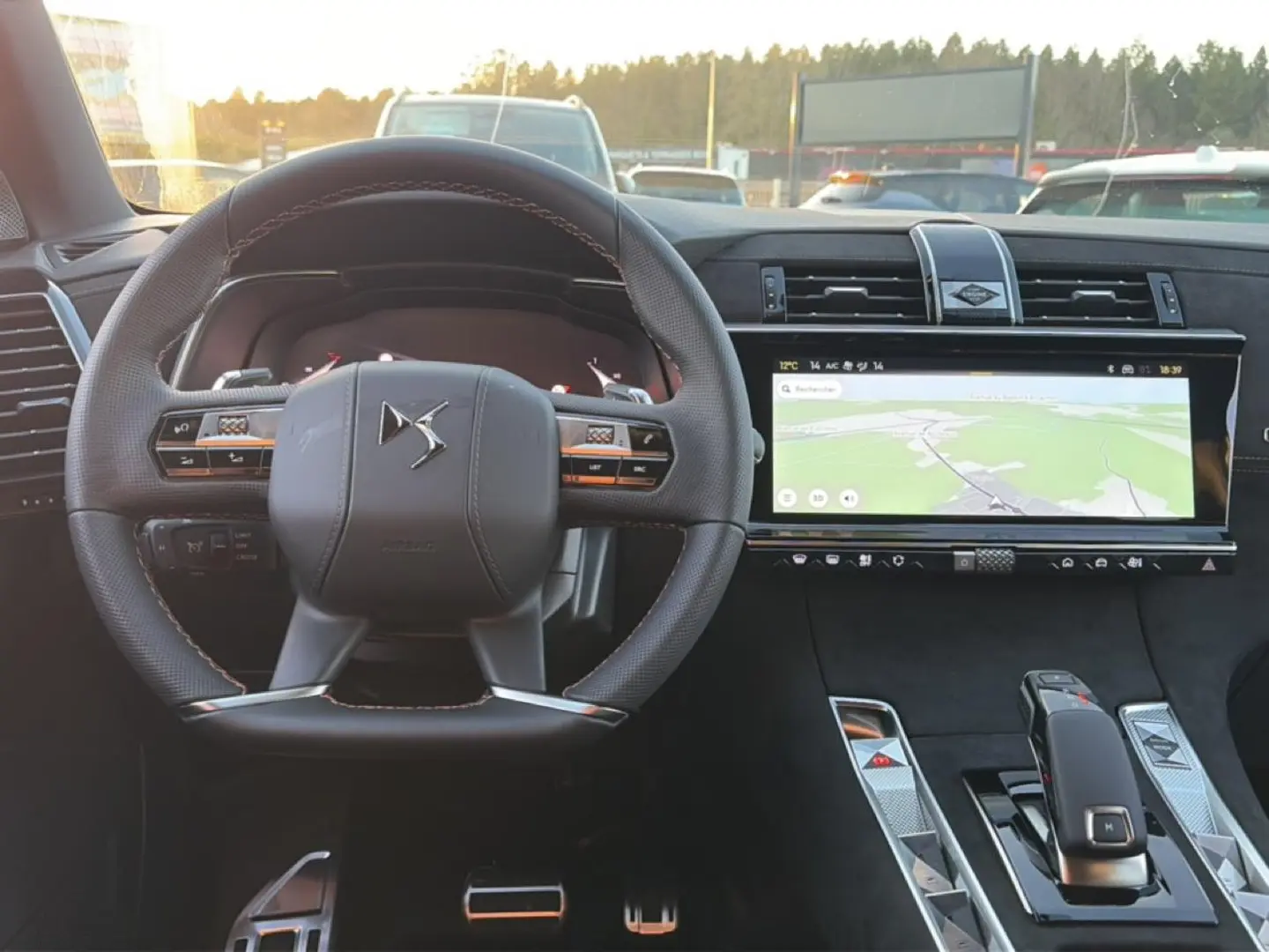 Vue intérieure centrée sur le volant cuir et l’écran tactile large du tableau de bord du DS7 noir 2026.