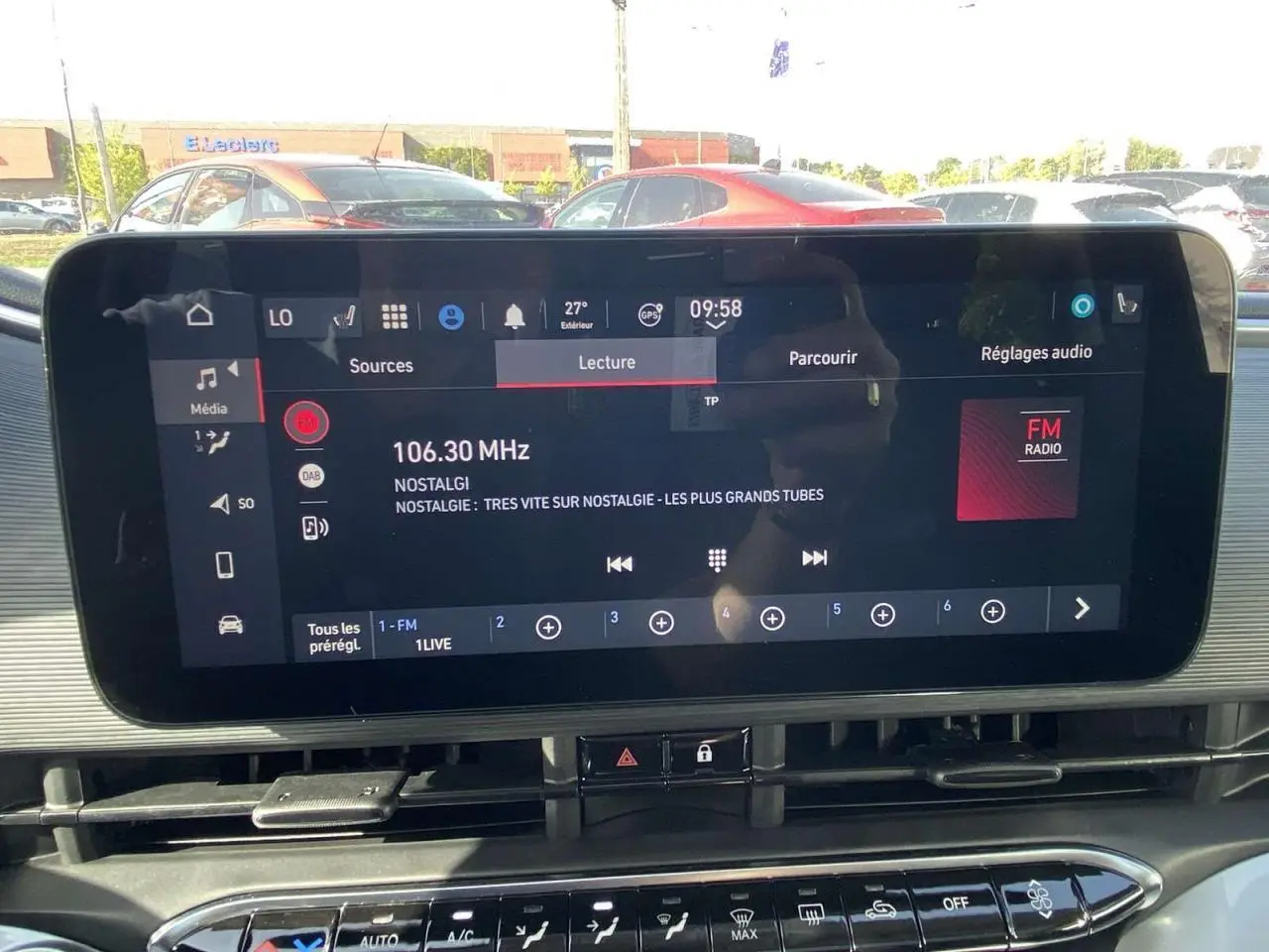 Écran tactile central du tableau de bord de la Fiat 500 Electrique noire, affichant la radio FM à 106.30 MHz.