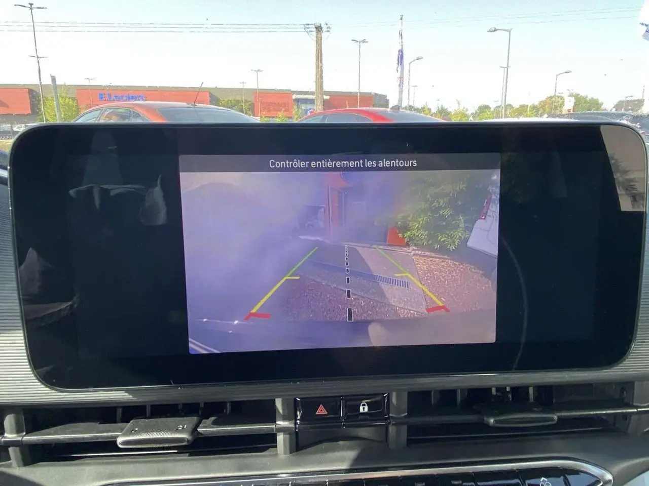 Écran central affichant la caméra de recul d'une Fiat 500 Electrique noire, vue depuis l'intérieur du véhicule.