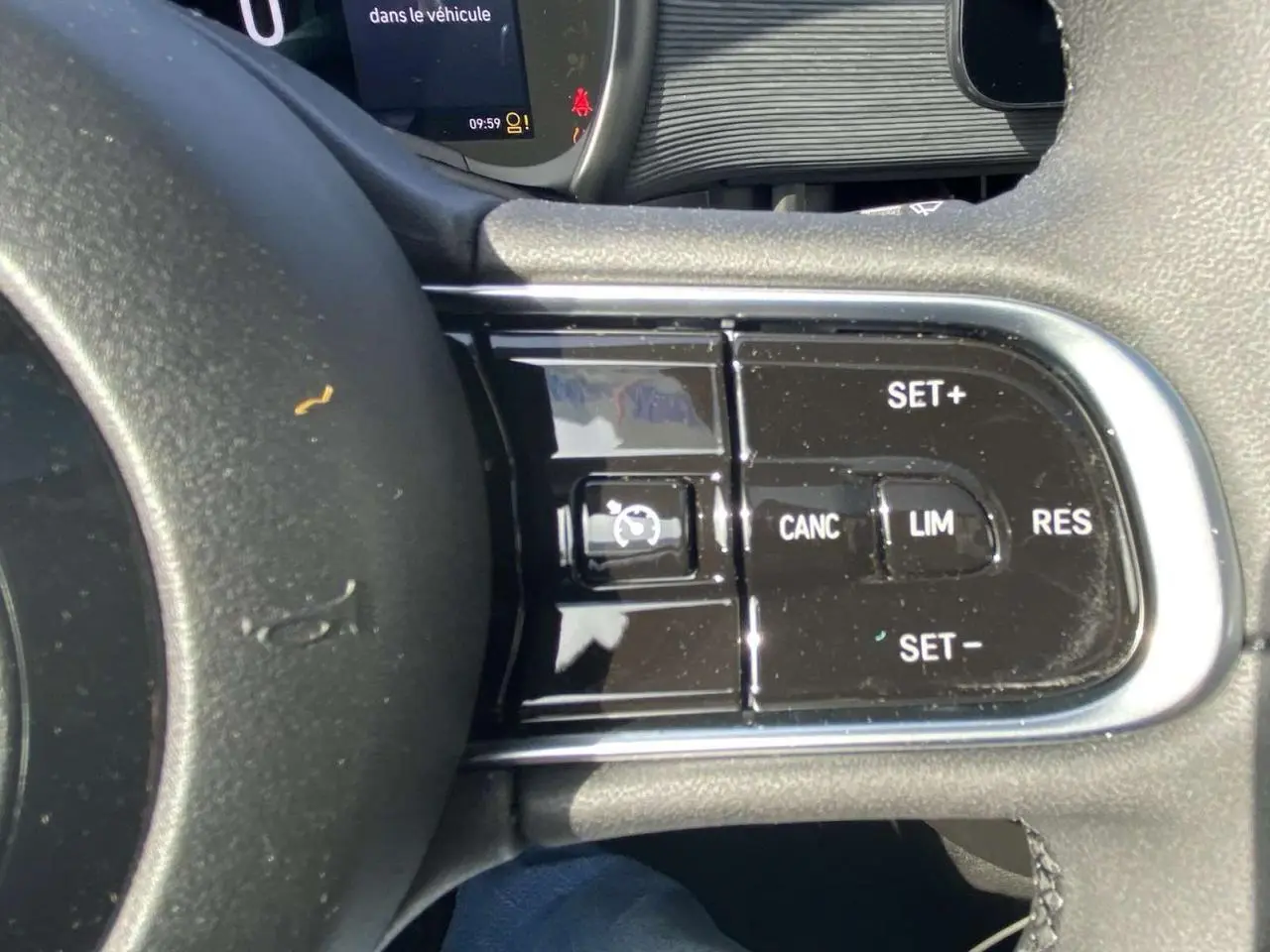 Gros plan sur les commandes du régulateur de vitesse au volant noir de la Fiat 500 électrique 2022.