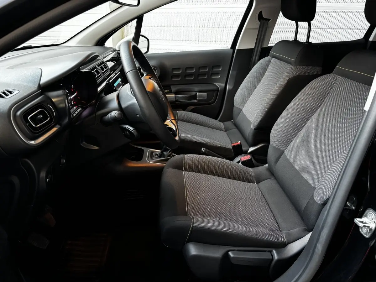 Intérieur de la Citroën C3 PureTech 110 gris clair, vue côté conducteur montrant sièges et tableau de bord moderne.