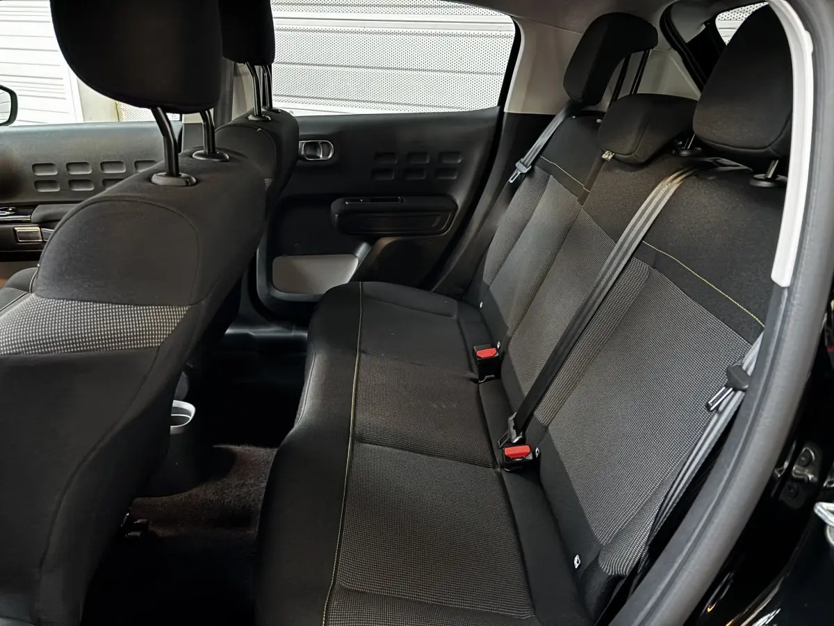 Banquette arrière noire vue côté droit dans une Citroën C3 2024, avec ceintures et appuie-têtes visibles.