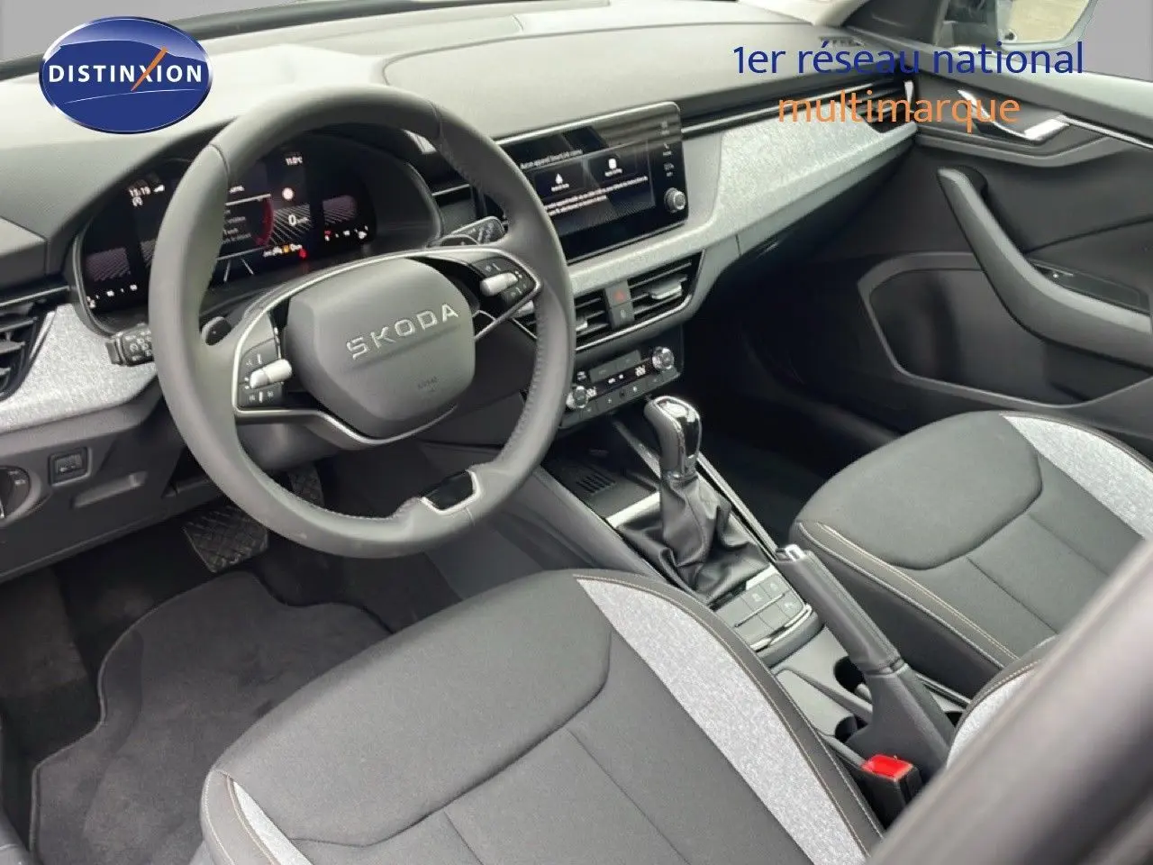 Vue intérieure côté conducteur du Skoda Kamiq noir magique métal, avec volant multifonction et console centrale moderne.