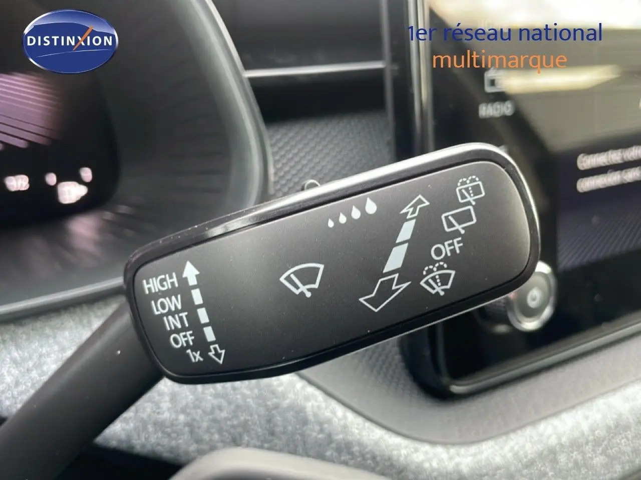 Gros plan sur la manette d'essuie-glace du Skoda Kamiq noir magique métal, avec tableau de bord en arrière-plan flou.