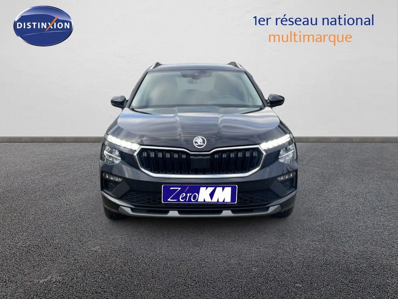 Vue de face d'un Skoda Kamiq noir magique métal avec calandre distinctive et feux LED allumés.