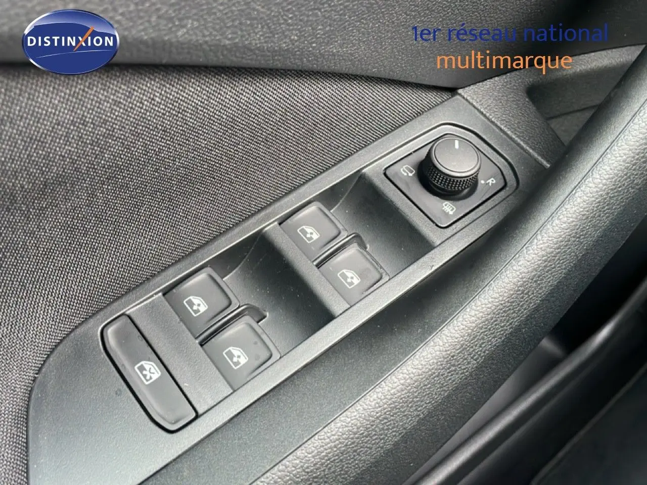 Gros plan sur les commandes des vitres électriques et rétroviseurs sur la porte côté conducteur d’un Skoda Kamiq noir magique métal.