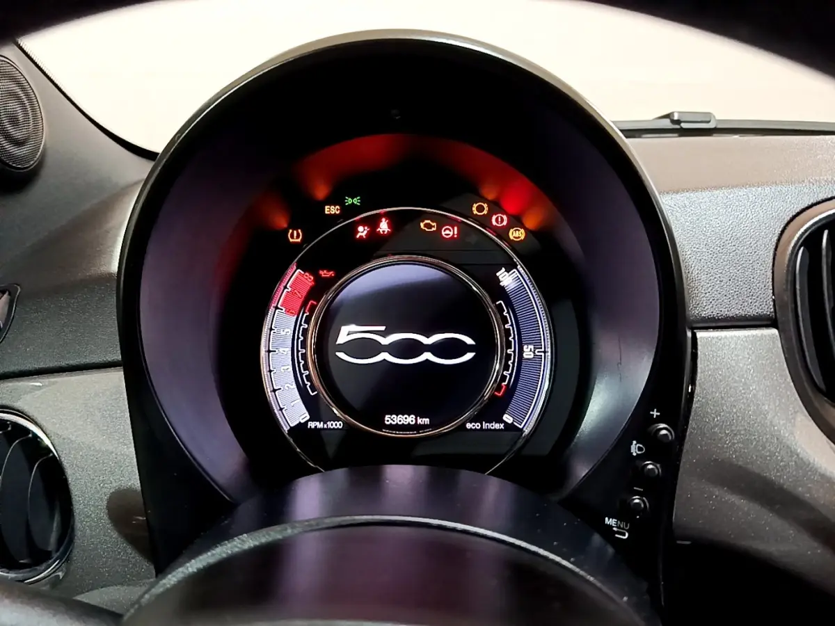 Vue rapprochée du tableau de bord numérique de la Fiat 500 gris foncé, avec affichage multifonctions et voyants allumés.