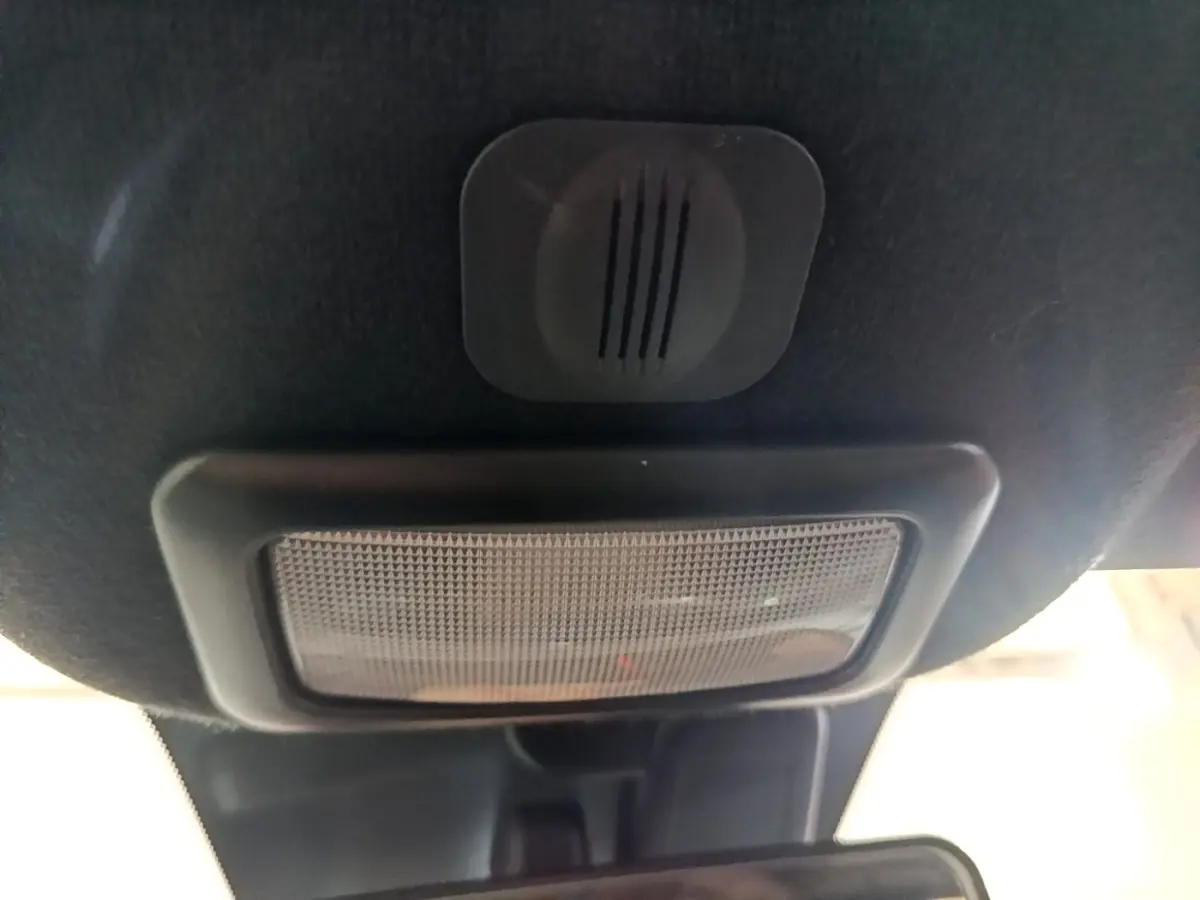 Gros plan sur l'éclairage intérieur et le micro du plafond d'une FIAT 500 gris foncé, vue vers l'avant.