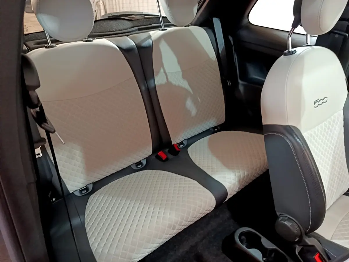 Vue intérieure sur les sièges arrière et avant beige matelassés de la FIAT 500 Hybrid gris foncé, version Dolcevita.