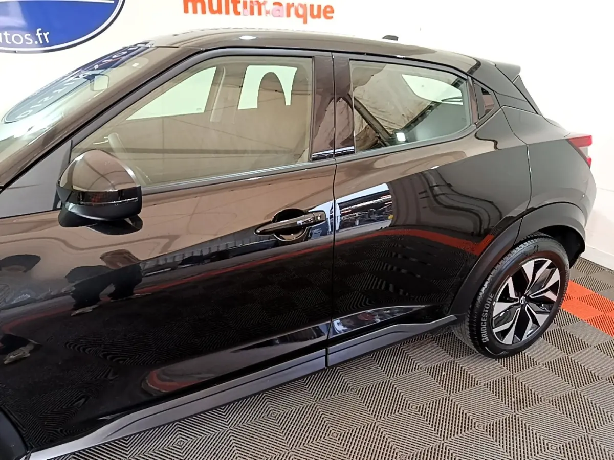 Vue latérale côté droit d'un Nissan Juke noir 2023 avec jantes alliage et rétroviseur ton caisse.