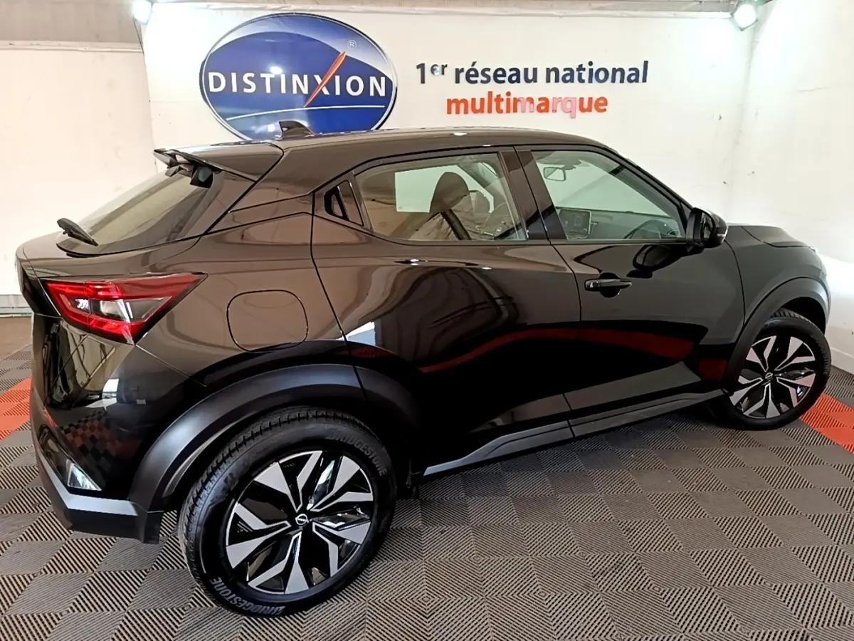 Vue 3/4 arrière droite d'un Nissan Juke noir 2023 avec jantes noires et détails de carrosserie lisse et moderne.